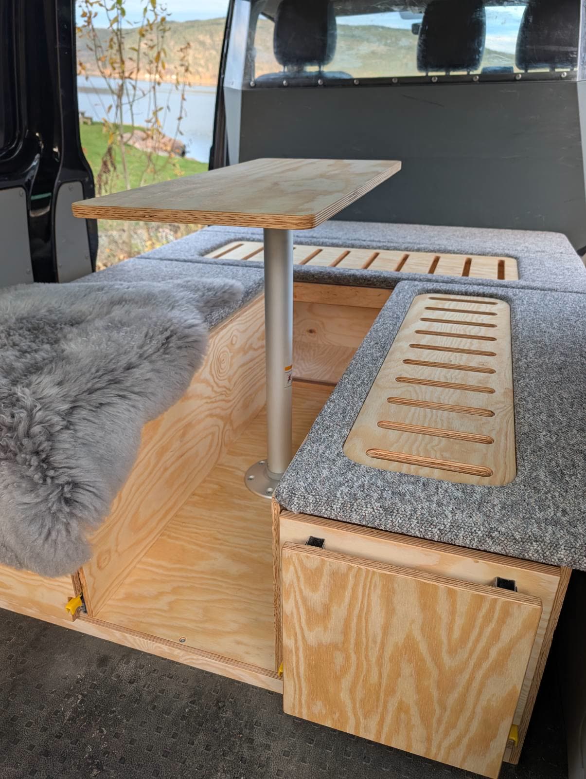 Sittegruppe med bord og saueskinn i varebilen